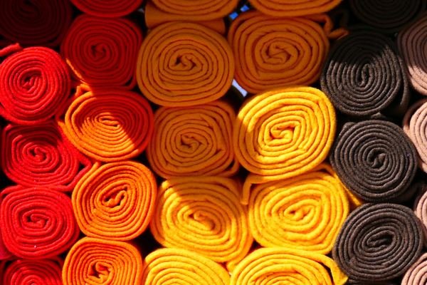 Rolled textile fabric stacked by colour
