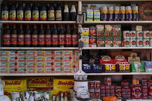 Shelves of packaged dry goods and bottled drinks in a general store